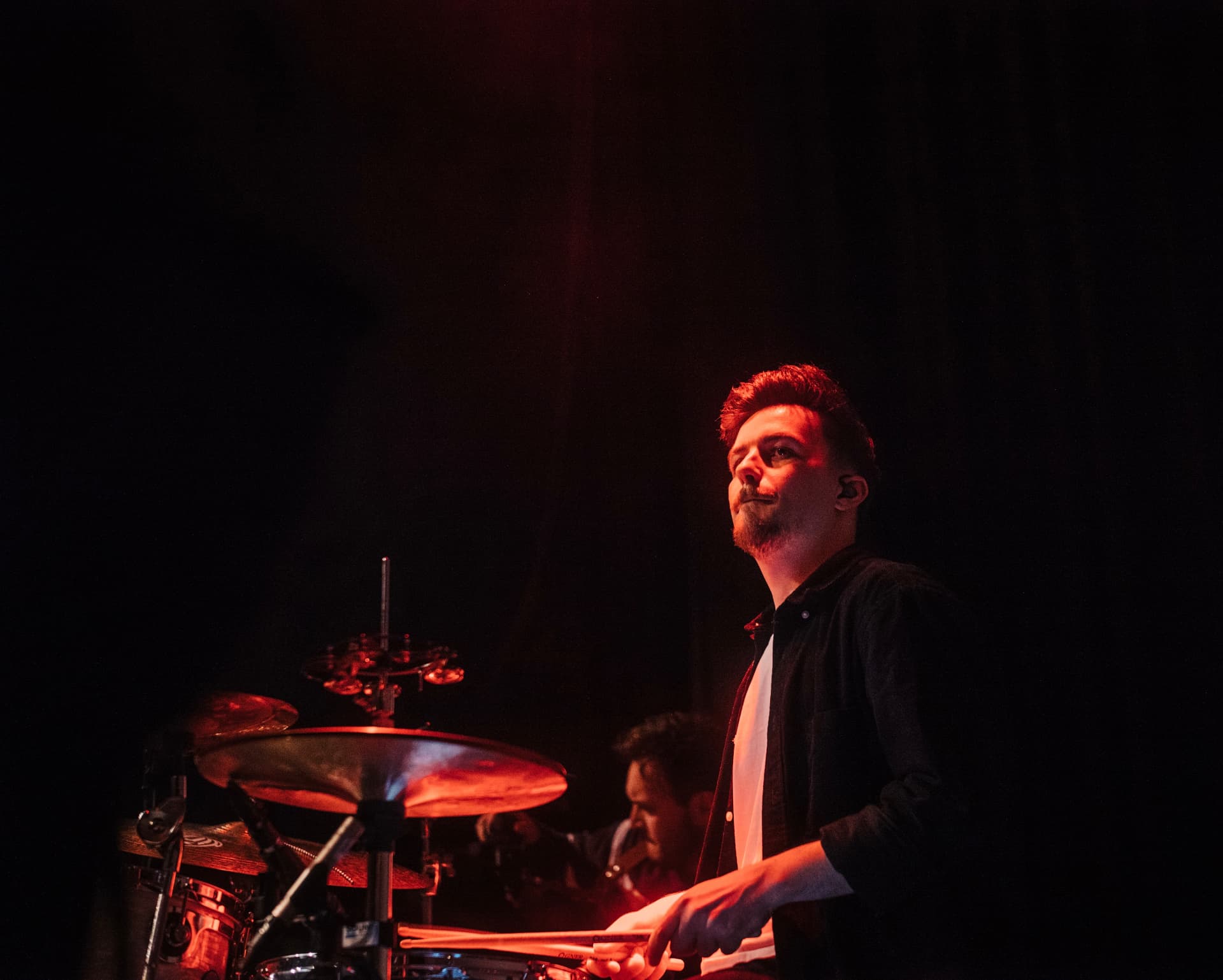 Julian Feuchter performing under deep red stage light